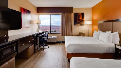 a hotel room with two beds and a desk and a television at Best Western View of Lake Powell Hotel in Page