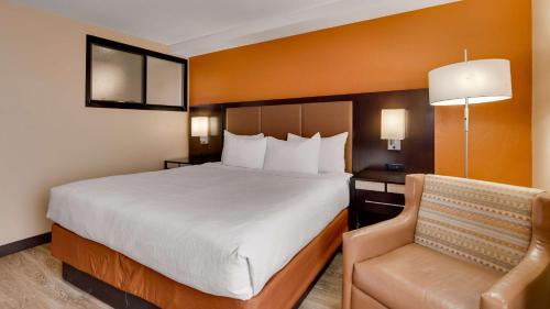 a hotel room with a bed and a chair at Best Western View of Lake Powell Hotel in Page
