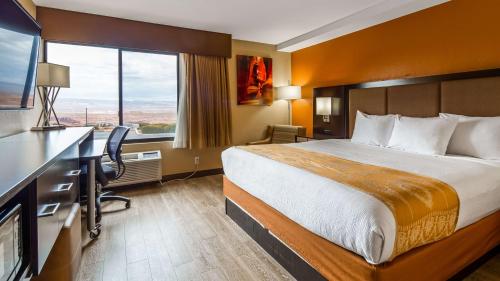 a hotel room with a bed and a desk and a window at Best Western View of Lake Powell Hotel in Page