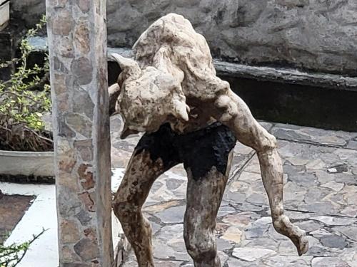 a statue of a person leaning against a pole at Hostal casa de las gargolas in Amapala
