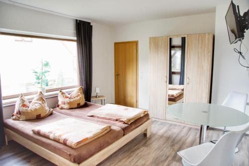 a bedroom with a bed and a glass table at Haff Ostseeferienhaus unteres Apartment in Mönkebude