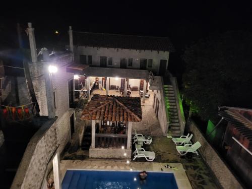an overhead view of a house with a swimming pool at night at Hostal casa de las gargolas in Amapala