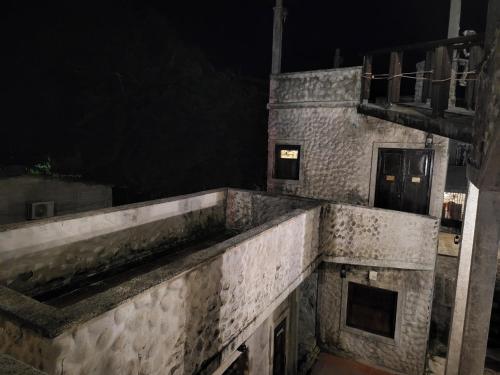 an old stone building at night with a door at Hostal casa de las gargolas in Amapala