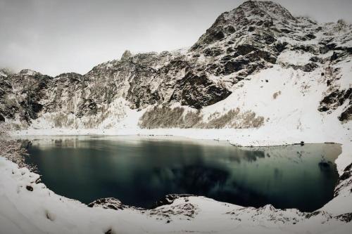 un cuerpo de agua frente a una montaña nevada en Logement 6 pers au cœur des montagnes pyrénéennes, en Boutx