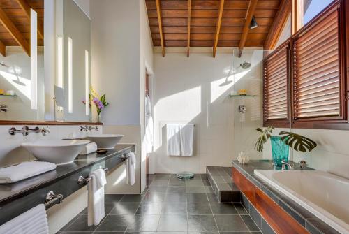 a bathroom with two sinks and a tub at Zoetry Marigot Bay - All Inclusive in Marigot Bay