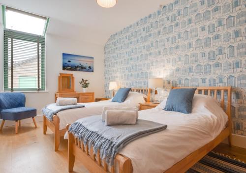 two beds in a bedroom with a wall ofartment at Pippins Lodge in Holt