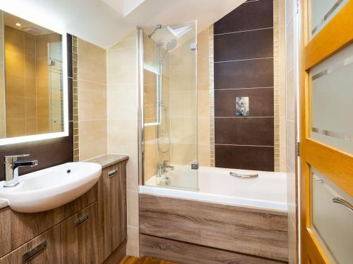 a bathroom with a sink and a tub and a shower at Willow Tree Barn in Kendal