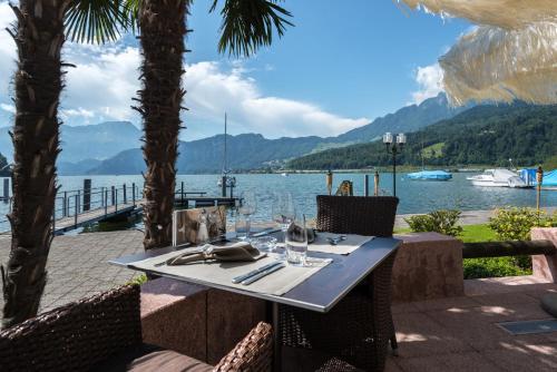 a table with wine glasses on it next to the water at Seehotel Sternen in Luzern