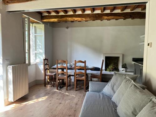 een woonkamer met een bank en een tafel met stoelen bij La Casina del Bassotto in Bagni di Lucca