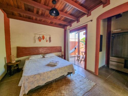 a bedroom with a bed in a room with a balcony at Free Soul House - Localização ideal no centrinho in Alto Paraíso de Goiás