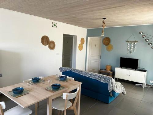 un salon avec une table et un canapé bleu dans l'établissement La Cabane aux lacs ~ Maison cosy au calme, à Aureilhan
