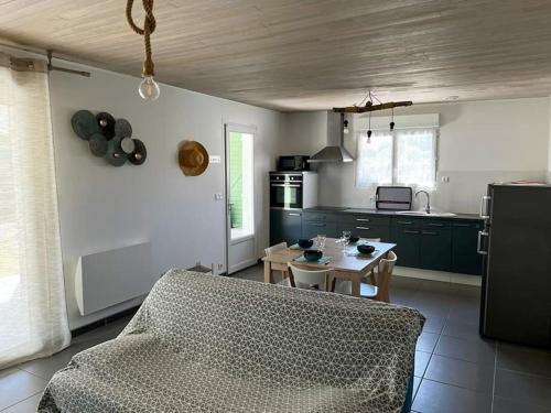 - une cuisine avec un canapé et une table dans une chambre dans l'établissement La Cabane aux lacs ~ Maison cosy au calme, à Aureilhan