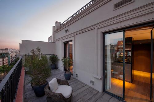 a balcony with chairs and tables on a building at Alma Barcelona GL in Barcelona