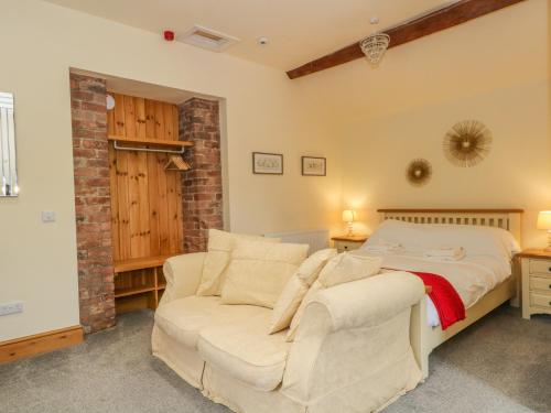 a bedroom with a bed and a couch at Swallows Nest in Macclesfield
