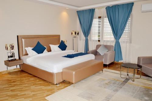 a bedroom with a large bed and a couch at Hôtel Printemps Mont Korhogo in Korhogo
