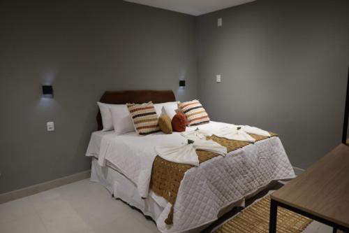 a bedroom with a bed with white sheets and pillows at Villa Xodó in Fernando de Noronha