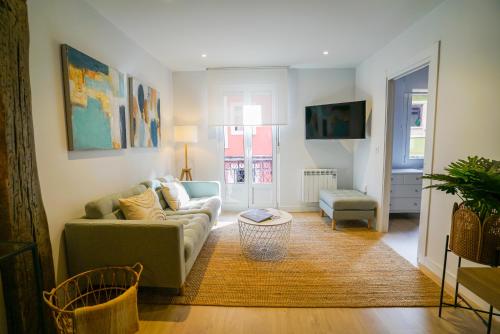 sala de estar con sofá y mesa en Homely Rooms, en Santander
