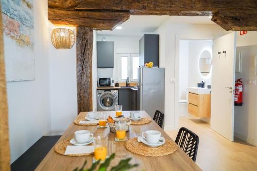 a dining room with a table and a kitchen at Homely Rooms in Santander