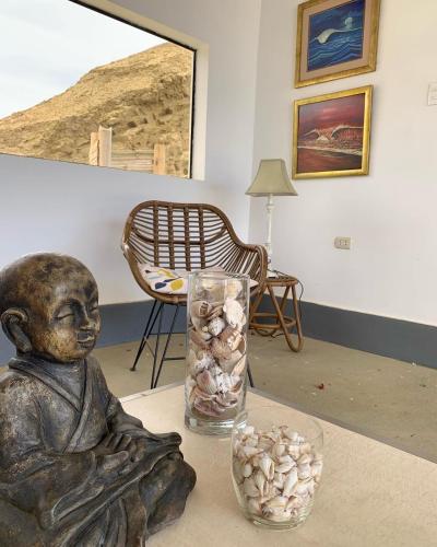 a statue of a child sitting on a table with a vase of shells at Aloha Lobitos in Lobitos