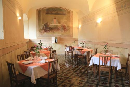 a restaurant with tables and chairs and a painting on the wall at La Locanda di San Pier Piccolo in Arezzo