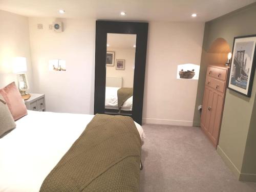 a bedroom with a large bed and a mirror at City Apartment, 2 min walk to Norwich centre. in Norwich