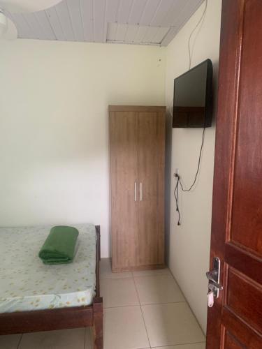 een slaapkamer met een bed en een tv in een kamer bij Hospedagem Entre Marés in Governador Celso Ramos