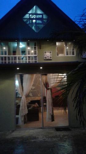 a house with a blue umbrella in front of it at Casa Grande Retiro para grupos in Cerro Azul