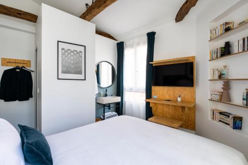 Baba Hotel في باريس: غرفة نوم بسرير ابيض ومرآة