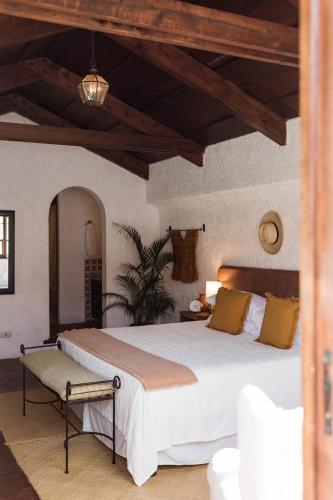 a bedroom with a large white bed with yellow pillows at Cacao Boutique Hotel in Antigua Guatemala
