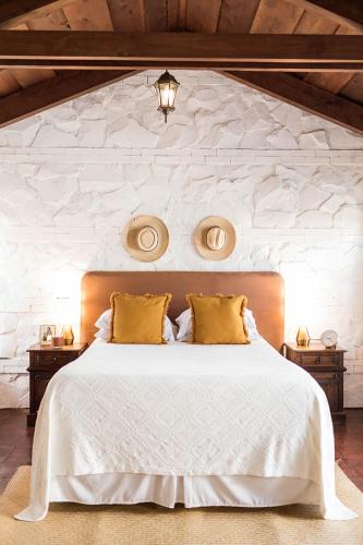 a bedroom with a large white bed with yellow pillows at Cacao Boutique Hotel in Antigua Guatemala