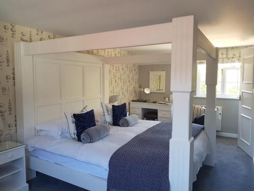 a bedroom with a large white bed with blue pillows at Random Hall in Slinfold