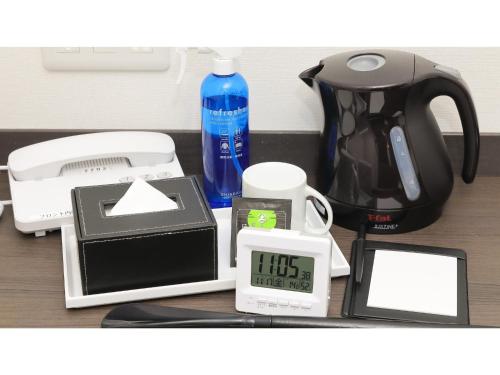 a table with a coffee maker a clock and a coffee pot at Eins,Inn Umeda Higashi - Vacation STAY 30031v in Osaka