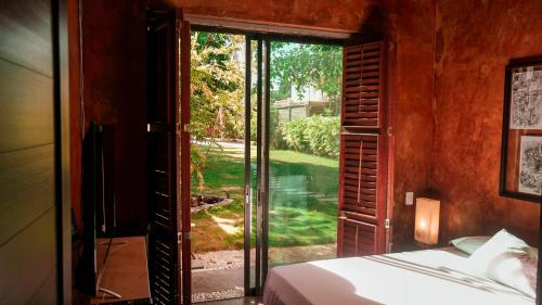 een slaapkamer met een bed en een glazen schuifdeur bij Villa Los Aguiluchos in Chetumal