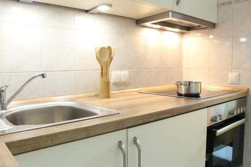 a kitchen with a sink and a wooden spoon at Ferienwohnung Krohn Cuxhaven in Cuxhaven