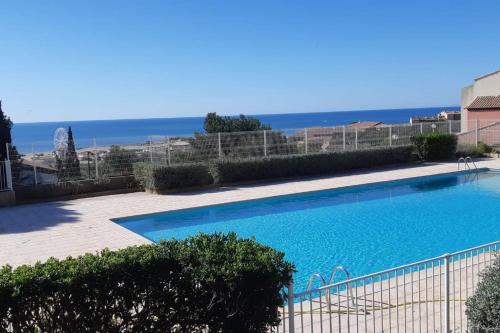 une grande piscine avec l'océan en arrière-plan dans l'établissement Appartement vue mer climatisé Seaview AC apartment Saint Pierre la Mer, à Fleury