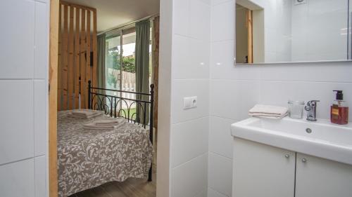 アレニス・デ・マルにあるHolidays en Arenys de Mar y Montañaの白いバスルーム(シンク、ベッド付)