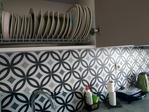 um balcão de cozinha com uma parede em azulejo preto e branco em Athens view apartment near Metro station Agia Marina em Atenas