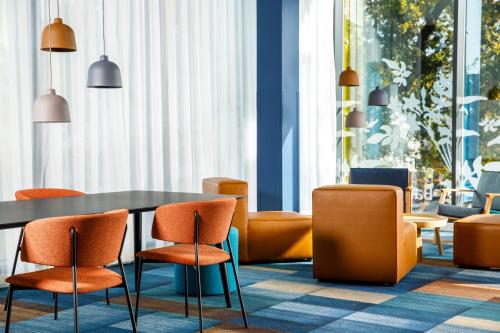 a dining room with orange chairs and a table at ibis budget London Heathrow Central in Hounslow