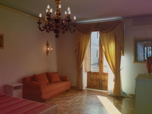 un soggiorno con divano e lampadario pendente di Perla di Naxos a Giardini Naxos