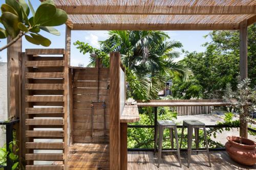 a wooden staircase leading to a patio with a table and stools at La Botanica Hotel in San Juan
