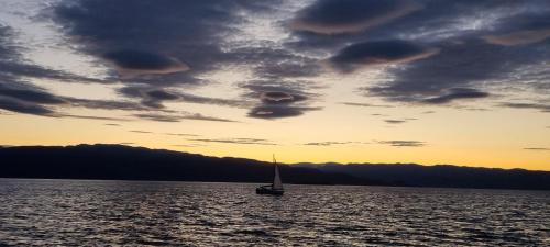 a sailboat in the middle of the water at sunset at Alta River Camping in Alta