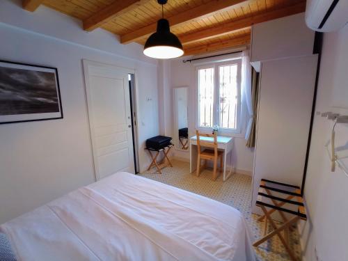 a bedroom with a bed and a table and a window at Casa Valparaíso Málaga for everybody in Málaga