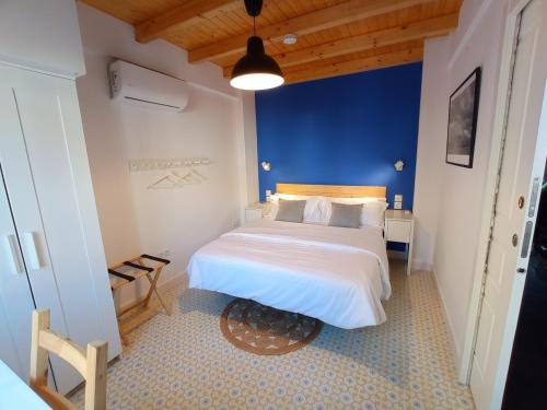 a bedroom with a large bed with a blue wall at Casa Valparaíso Málaga for everybody in Málaga