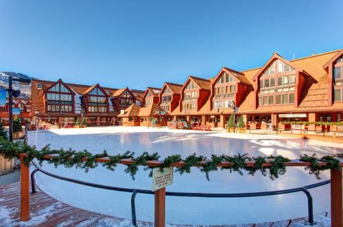 パークシティにあるThe Lodge at Mountain Villageのリゾート 建物の前に大きなアイススケートリンクがあります。