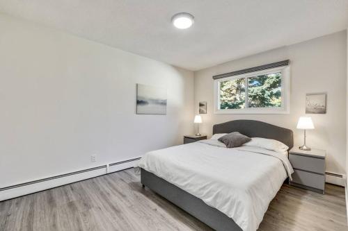 a white bedroom with a bed and a window at Roxboro #1 Premium Central 3BR Home Parking, Wifi in Calgary