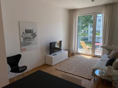 a living room with a couch and a tv at Modernes City Apartment im Scandinavian Design in Hamburg