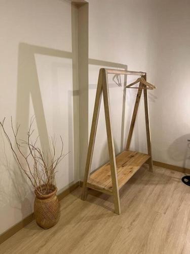 a wooden stand next to a vase with a plant at Apartamento en planta baja cerca a Laureles NID103 By Roots Rentals in Medellín