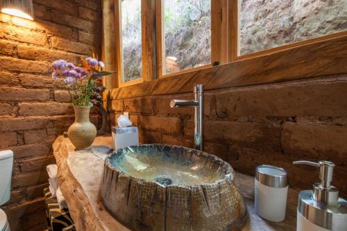 un bagno con lavandino in legno e stupefacente in legno di Lofts in The Forest a Avándaro