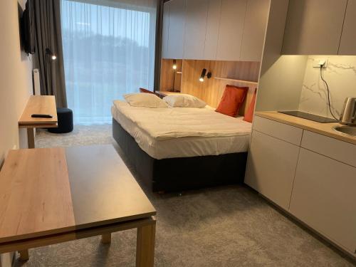 mały pokój hotelowy z łóżkiem i kuchnią w obiekcie Wilanów Residence Apartments w Warszawie