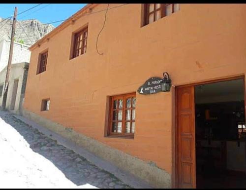 un edificio naranja con un letrero en el costado. en El mirador de iruya en Iruya